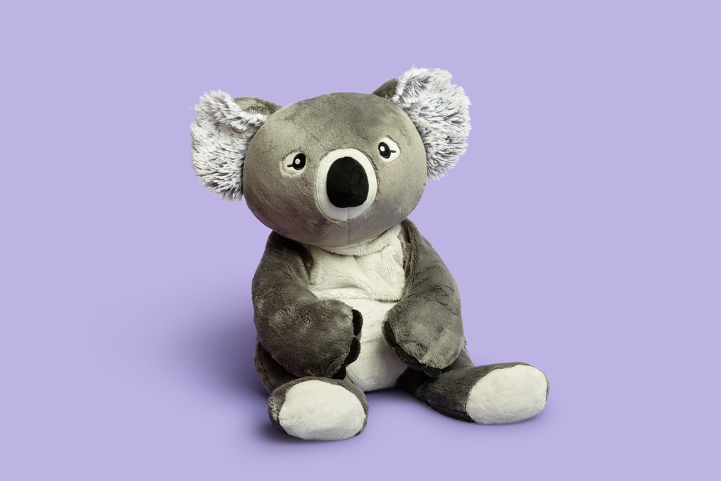 This photo shows Quinn the Koala Hugimal in a cute seated pose on a purple background